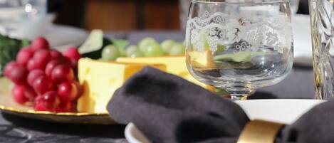 A dining table with a plate of cheese and grapes, a glass of water, and a napkin.