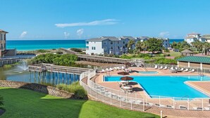 Resort com piscina grande, píer e vista para o oceano.