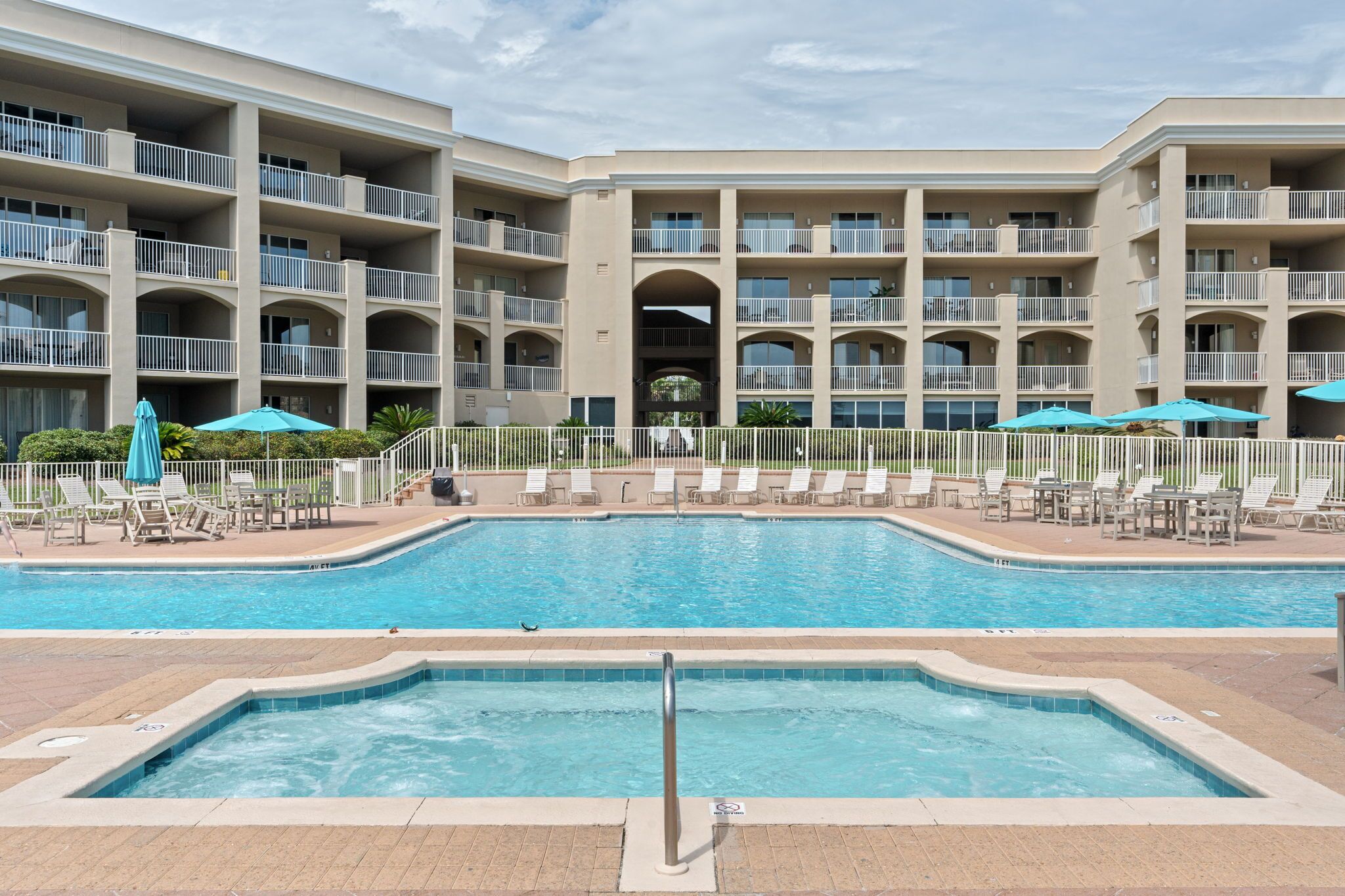 Un hôtel doté d’une piscine, de chaises longues et de parasols.