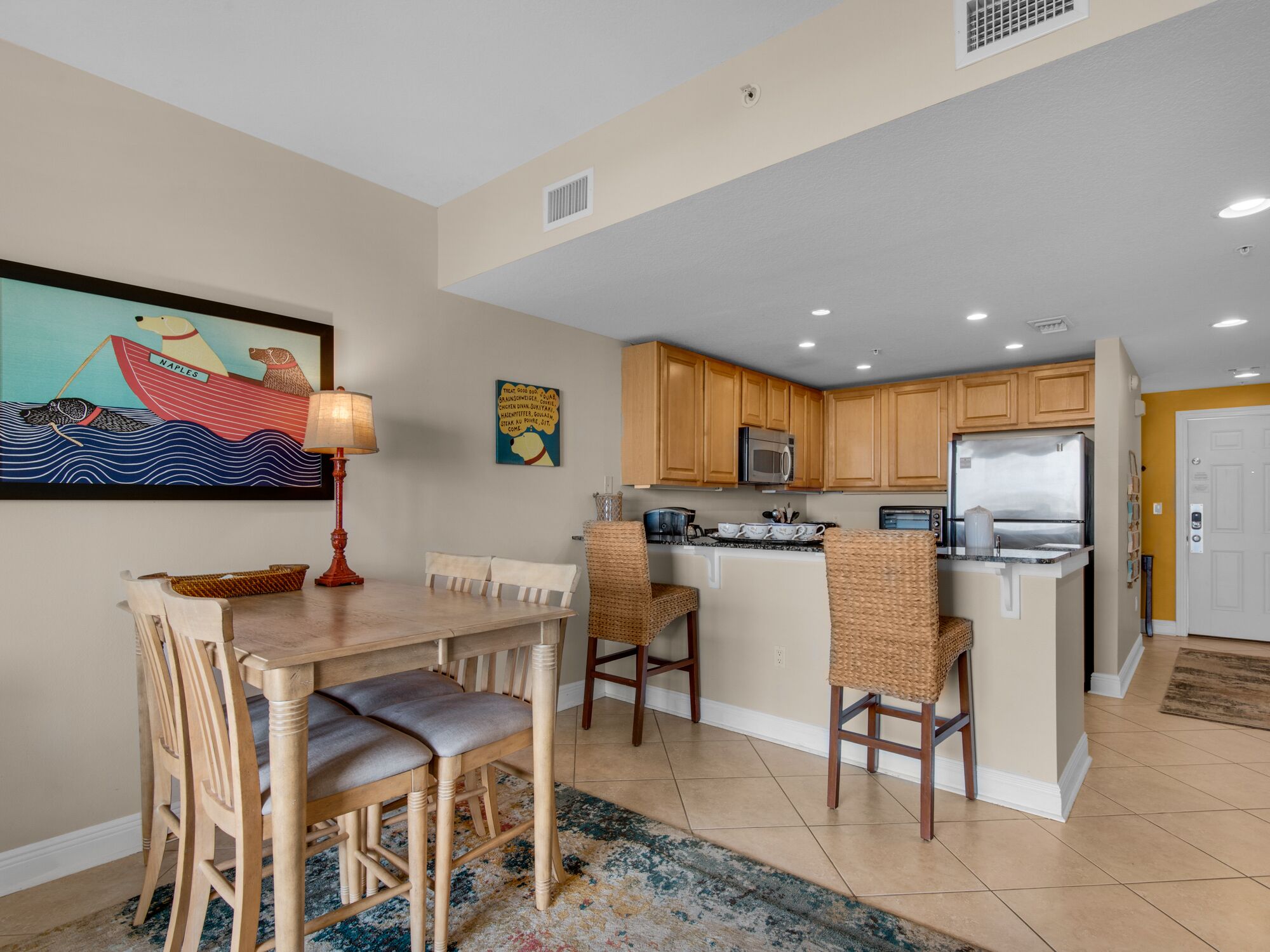 A kitchen with wooden cabinets, a refrigerator, and a microwave.