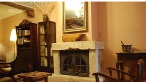 A cozy living room with a fireplace, a bookshelf, and a chair. - La Noguera de Socasa for 14 people (Brihuega)