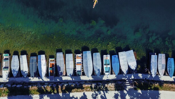 A row of boats lined up against a body of water.