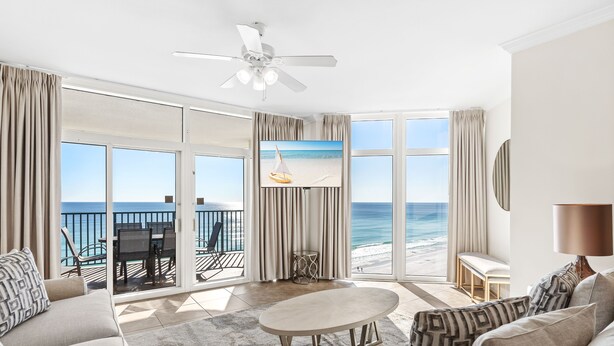 A spacious living room with a large window overlooking the ocean, a ceiling fan, and a view of the beach. - Gulf Front Balcony, Gorgeous Views, Near Destin Harbor (Destin)