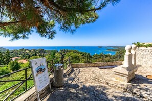 A stone pathway leading to a viewpoint overlooking a coastal landscape with clear skies. - Villa Carla | Istrian Stone Villa with Sea View (Vrsar)