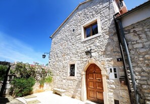 A stone building with a wooden door and a small window. - Villa Carla | Istrian Stone Villa with Sea View (Vrsar)