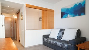 Een moderne woonkamer met een bank, een houten tafel en een schilderij aan de muur.