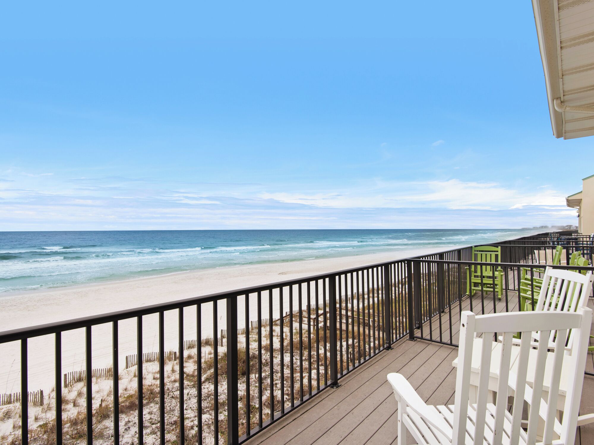 Ein Balkon mit Blick auf Strand und Meer.