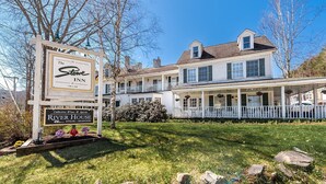 A two-story building with a porch, a sign for 'The Stowe Inn' and 'River House Steak & Seafood'.