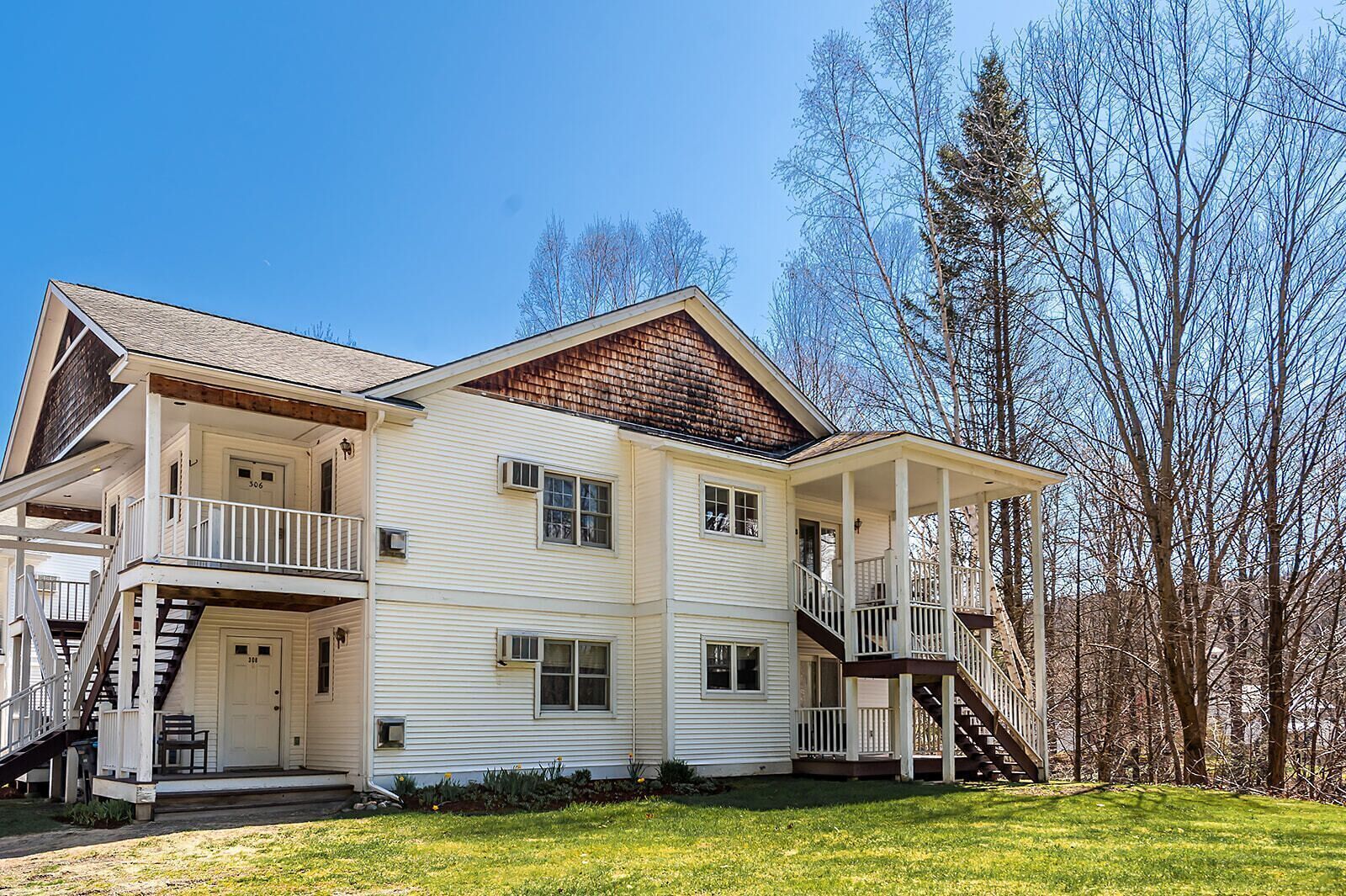 A two-story house with a porch, a staircase, and a small front yard.