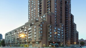 Un edificio de gran altura con varios pisos, amplias ventanas y fachada plana.