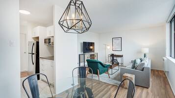 A modern apartment with a dining area, kitchen, and living room.