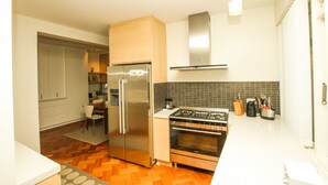 Eine moderne Küche mit einem Edelstahl-Kühlschrank, Backofen und einem Gasherd.
