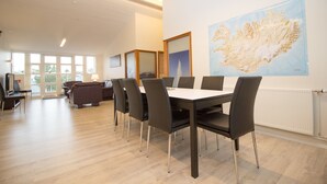 Un salón de conferencias con una gran mesa y sillas, un mapa en la pared y vistas al exterior a través de amplias ventanas.