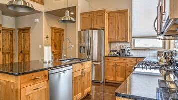 A modern kitchen with wooden cabinets, stainless steel appliances, and a granite countertop.
