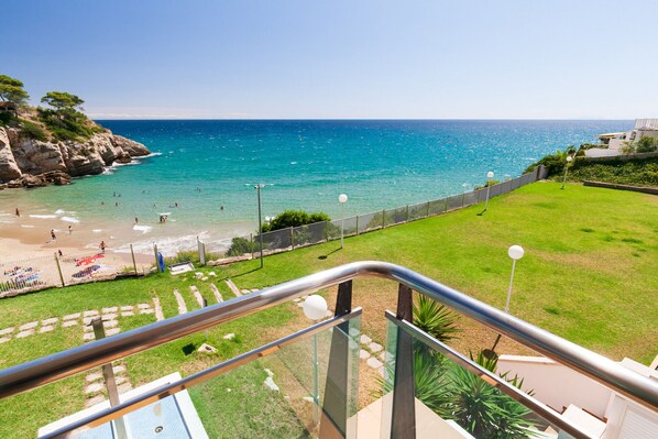 A balcony with a view of a beach and ocean.