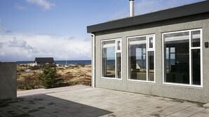A modern building with large windows and a view of the sea.