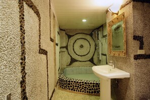 A bathroom with a leopard print bathtub, a white sink, and a mirror on the wall. - Penghu Kite House (Magong)