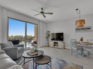 Relax in this stylish living room with a sofa, coffee table, and dining area leading to a balcony.