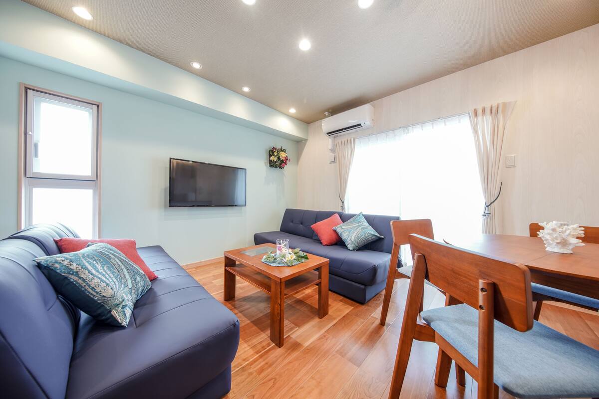 A modern living room with a sofa, a coffee table, and a dining table.