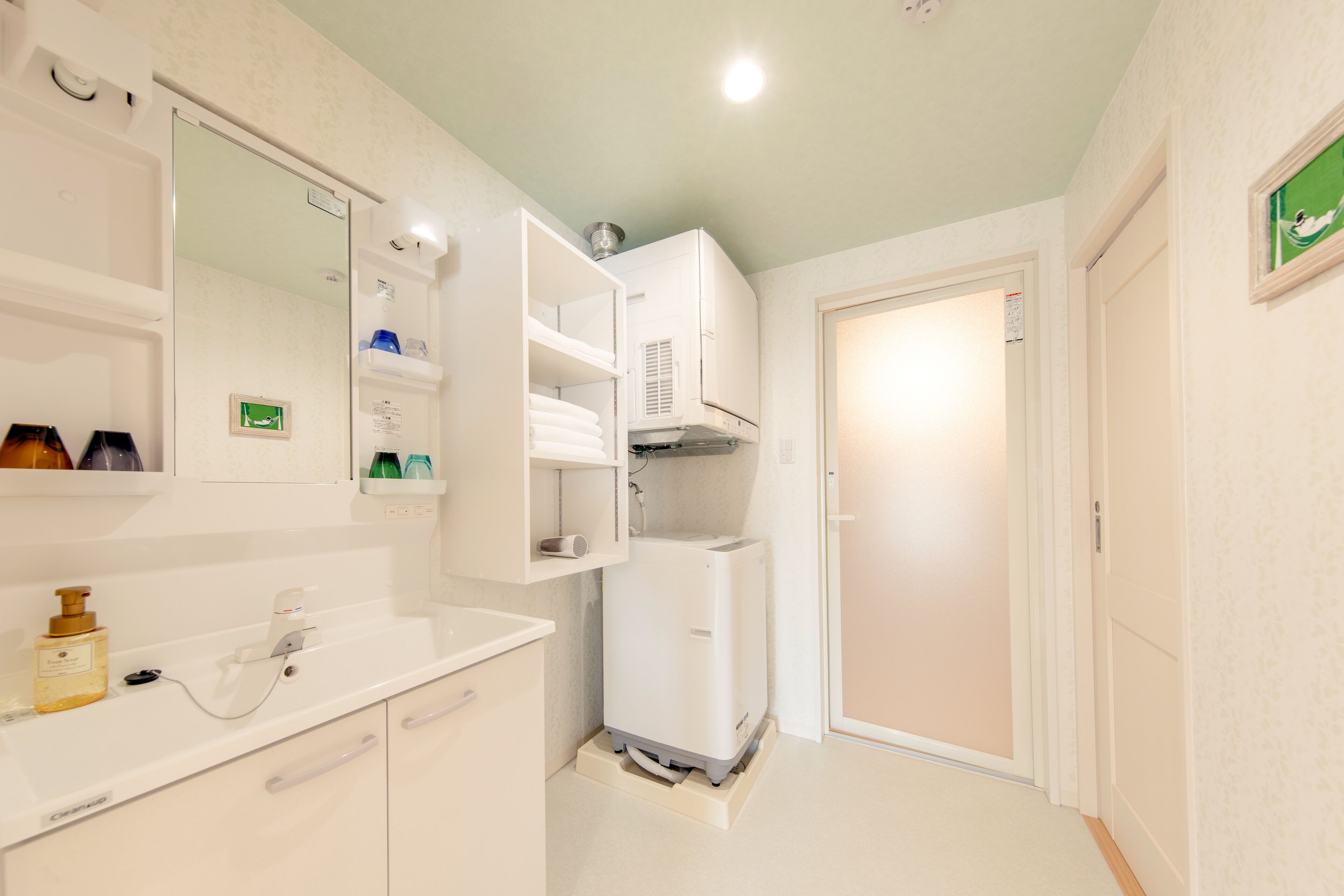 Uma casa de banho moderna com lavatório branco, espelho e aquecedor embutido.