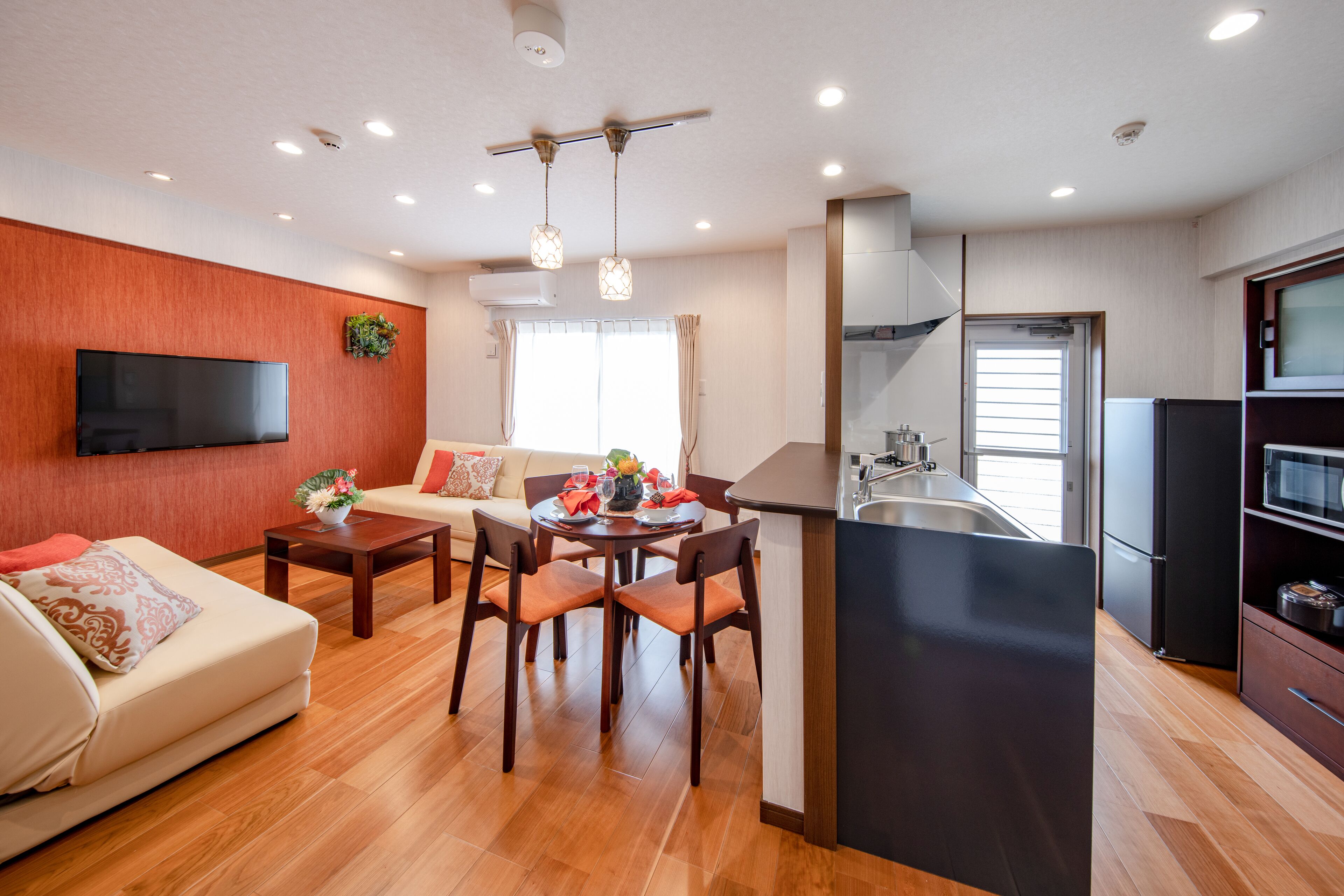 Een modern appartement met een woonkamer, eethoek, keuken en een balkon.