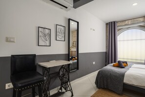 Une chambre à coucher moderne avec un lit, un bureau, une chaise et un grand miroir.