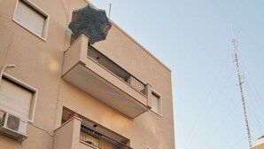 Un immeuble à plusieurs étages, doté de balcons et de climatiseurs, avec un ciel dégagé.