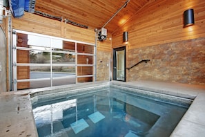 Relax by the rectangular pool surrounded by a smooth deck and wooden paneling.
