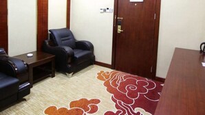 A conference room with a wooden door, a black leather chair, a small table, and a patterned carpet. - Shenzhen Hanlinxuan Business Hotel (Shenzhen)