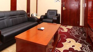 A conference room with a black leather sofa, a wooden table, and two black leather chairs. - Shenzhen Hanlinxuan Business Hotel (Shenzhen)