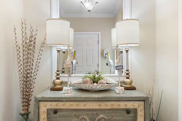 A vintage dresser with two lamps, a mirror, and decorative items.