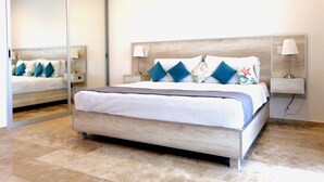 A modern bedroom with a large bed, bedside lamps, and a mirror.