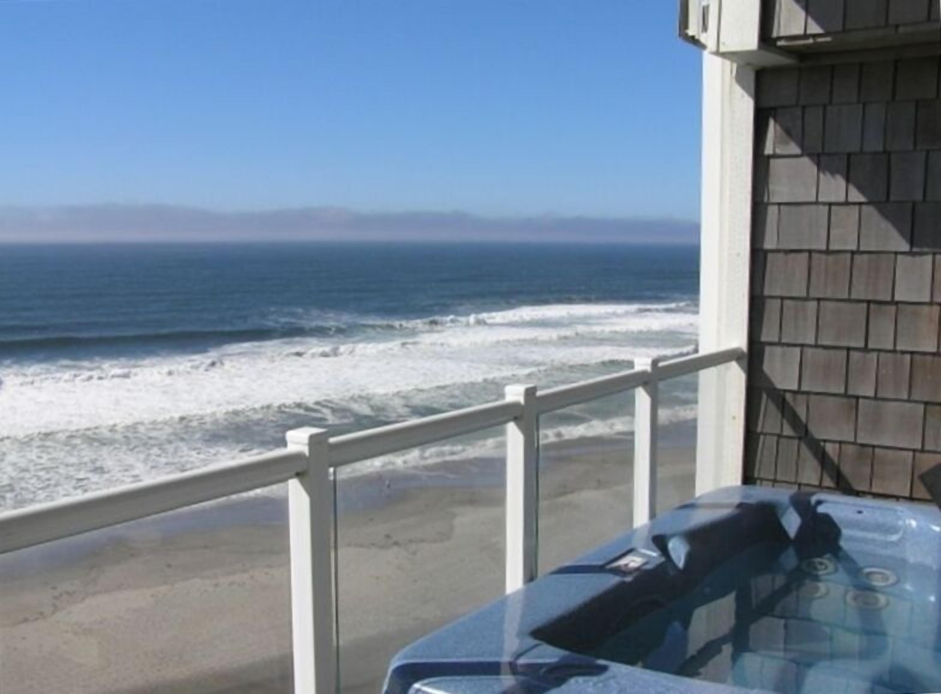 Un balcone con vista sull'oceano e vasca idromassaggio.