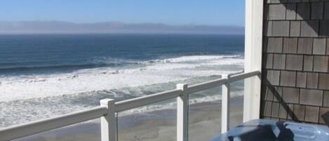 Un balcone con vista sull'oceano e vasca idromassaggio.