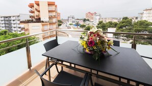Un balcone con un tavolo apparecchiato per due, impreziosito da un centrotavola floreale.