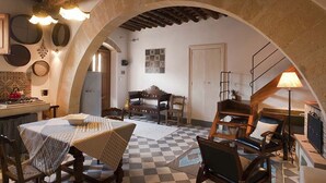 Un intérieur rustique avec un sol à carreaux, des meubles en bois et une arche en pierre.