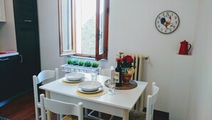 Une table à manger avec des assiettes, une bouteille de vin et un vase de fleurs.