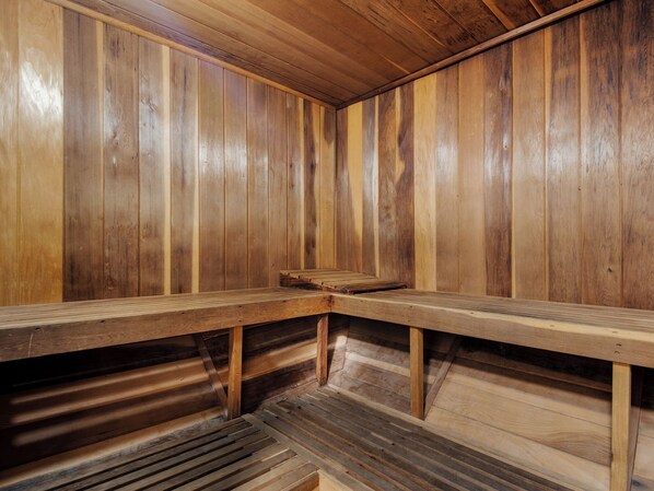 Un sauna avec des bancs en bois et un plancher à lattes.