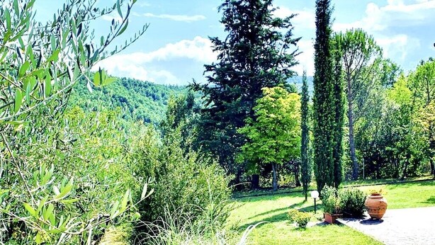 A garden with a pathway, a chair, and a pot. - The House Of Antonella Casentino, Arezzo, Tuscany, Italy  (Subbiano)
