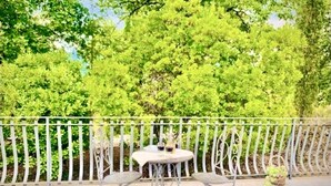A balcony with a round table and two chairs, surrounded by a white metal railing. - The House Of Antonella Casentino, Arezzo, Tuscany, Italy  (Subbiano)