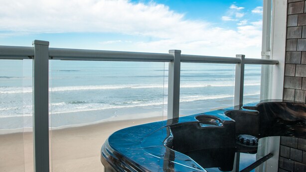 Een balkon met uitzicht op strand en zee.