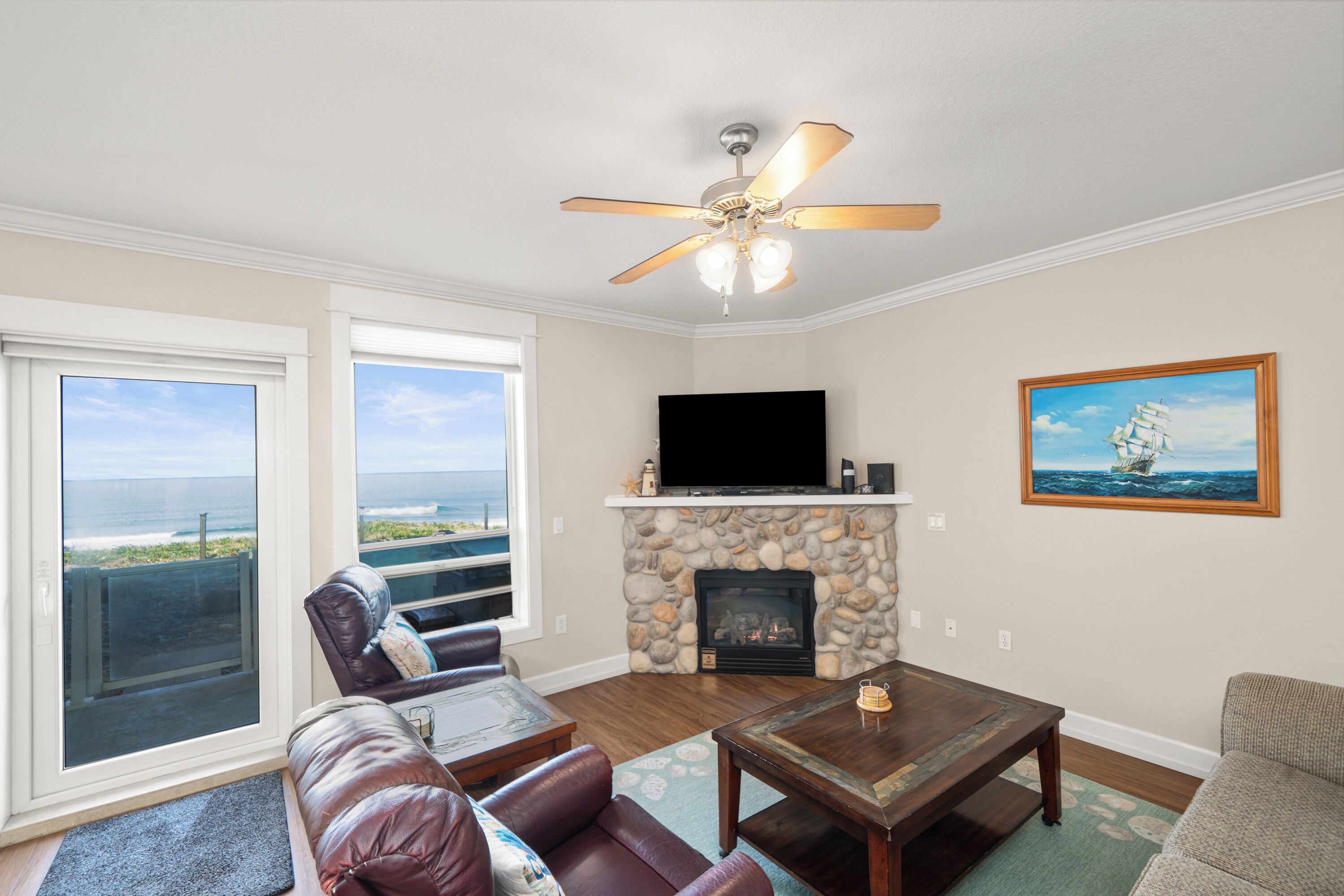 A living room with a fireplace, a television, and a painting.