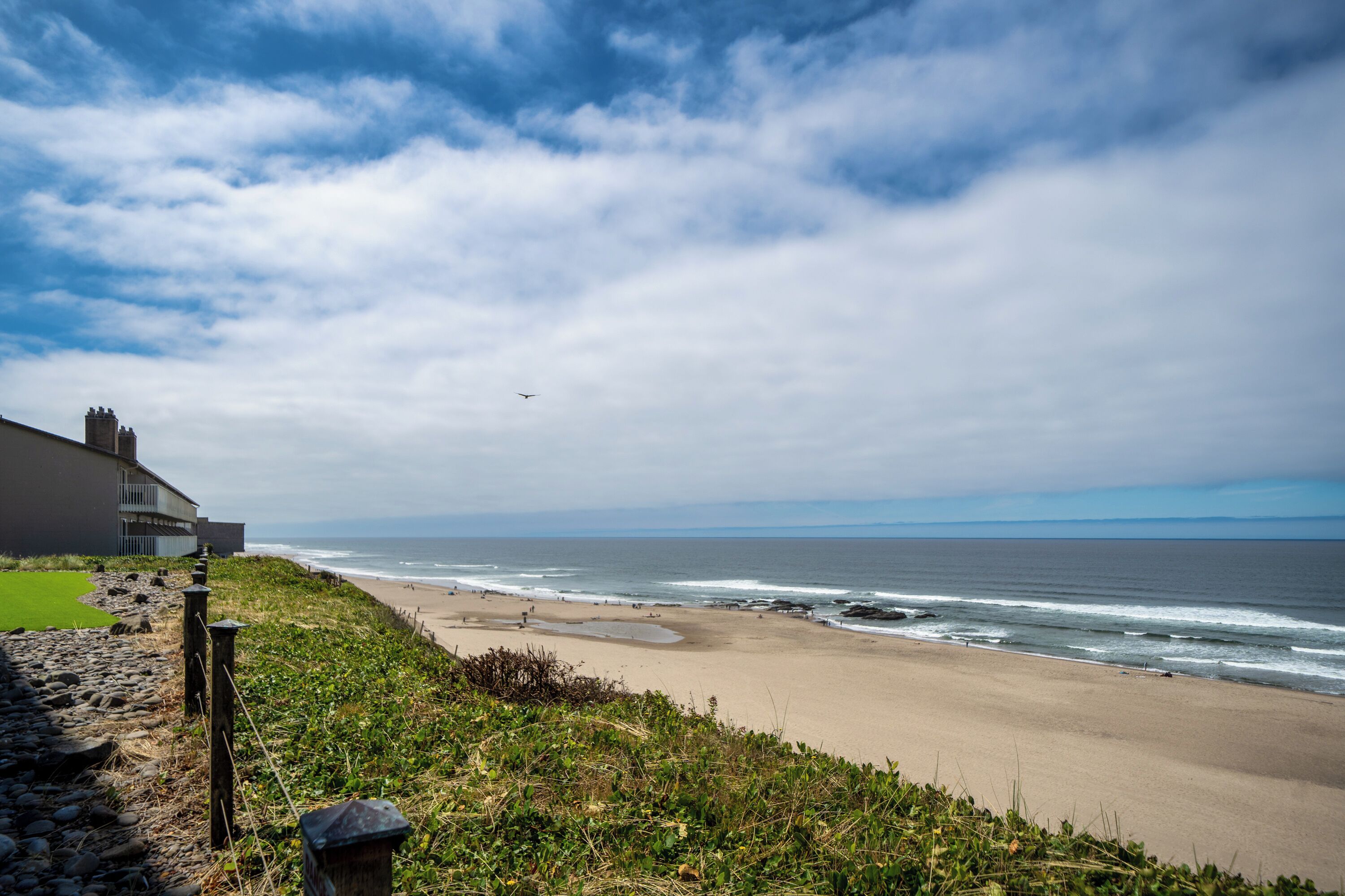 Eine Küstenlandschaft mit Strand, Meereswellen und blauem Himmel.