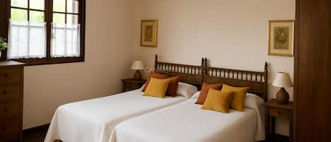 A bedroom with two beds, wooden headboards, bedside tables with lamps, and a window with curtains.