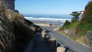 Una carretera costera con pilares de piedra que conduce a una playa.
