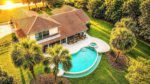 A house with a swimming pool, surrounded by palm trees and a well-maintained lawn. - SWISS 41 - Golf Course (Clermont)