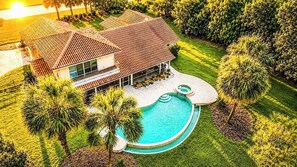 A house with a swimming pool, surrounded by palm trees and a well-maintained lawn. - SWISS 41 - Golf Course (Clermont)