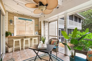 A covered patio with a table, chairs, and potted plants. - Ground Floor, Walk to the Beach, Pool,  Beach Chair Service Included (Miramar Beach)