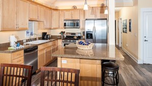 Une cuisine moderne avec des meubles en bois, des appareils en acier inoxydable et un plan de travail en granit.