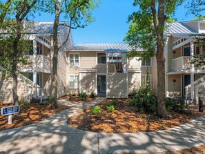 A residential building with a central courtyard, surrounded by trees.